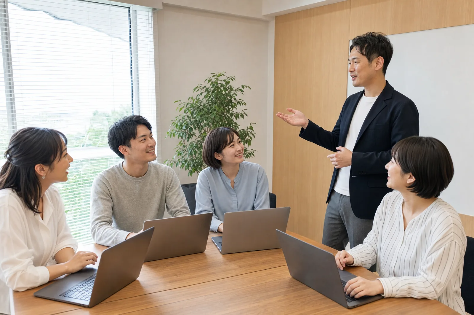 会議室で社員がノートパソコンを前に研修を受けている写真